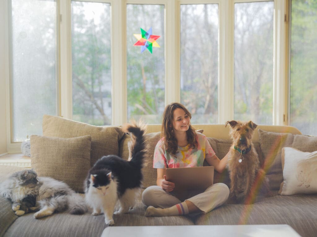 Woman on sofa with cats and dog.